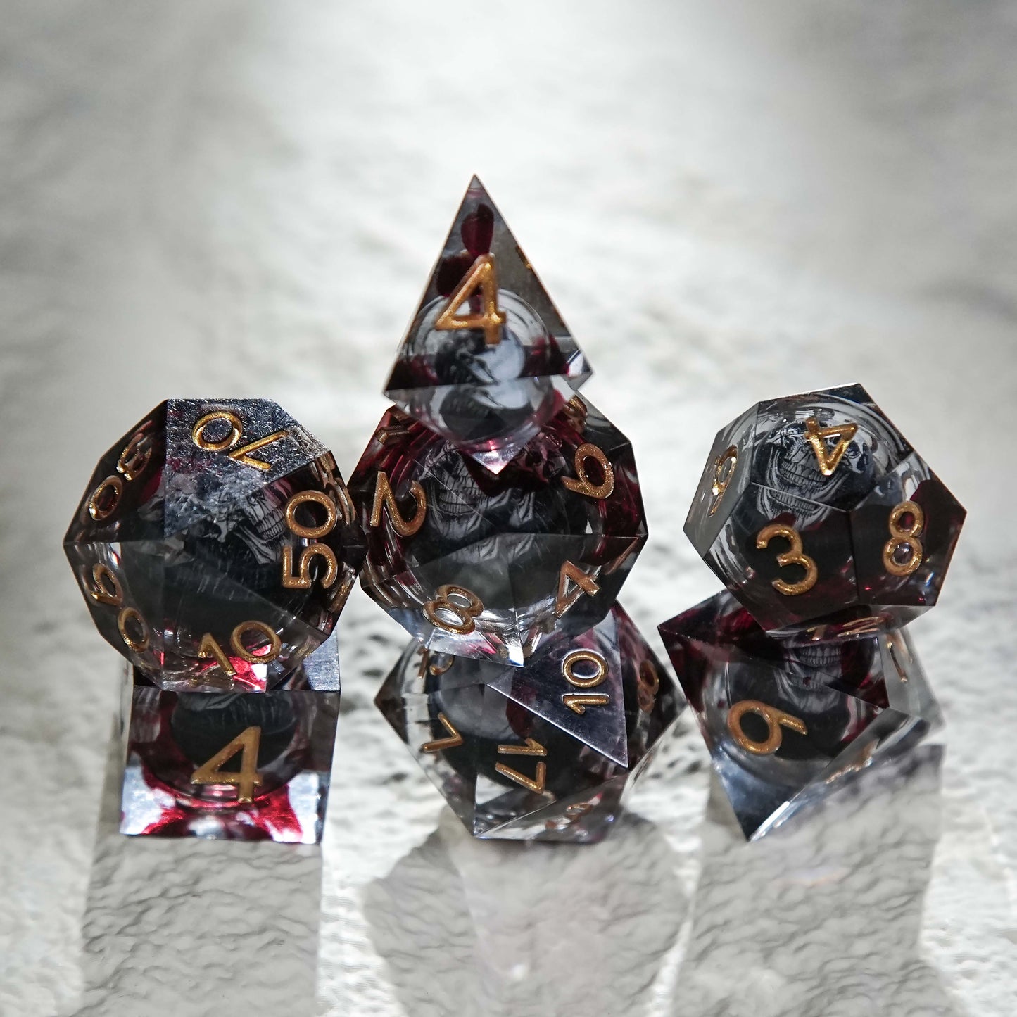 Juego de dados de resina con núcleo de calavera, mancha de sangre negra y números dorados 