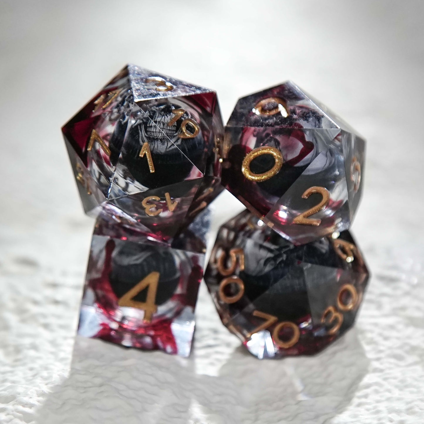 Juego de dados de resina con núcleo de calavera, mancha de sangre negra y números dorados 