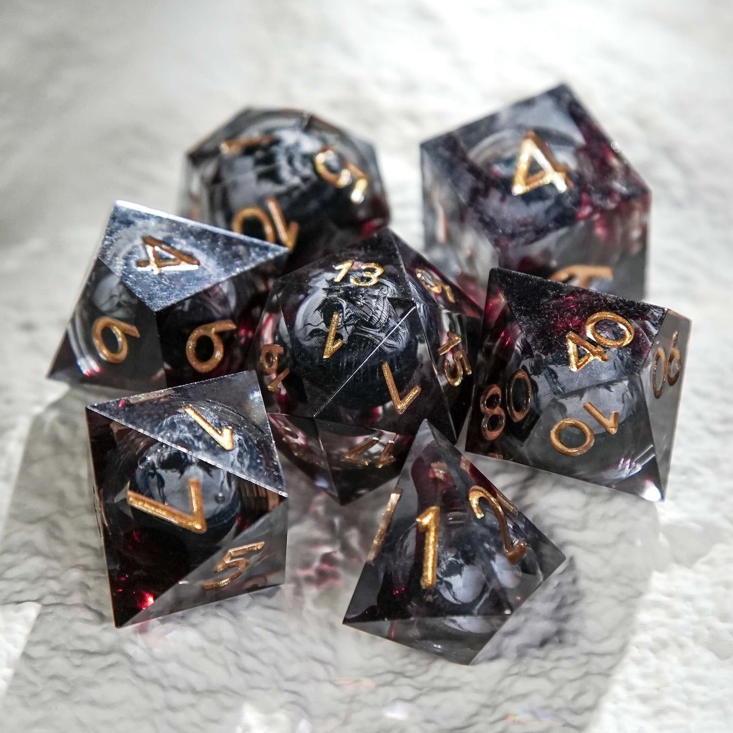 Juego de dados de resina con núcleo de calavera, mancha de sangre negra y números dorados 